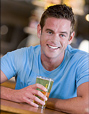 Young man smiling with a beer in his hand.